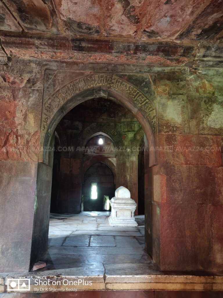 Red sandstone arches with Quranic Inscriptions